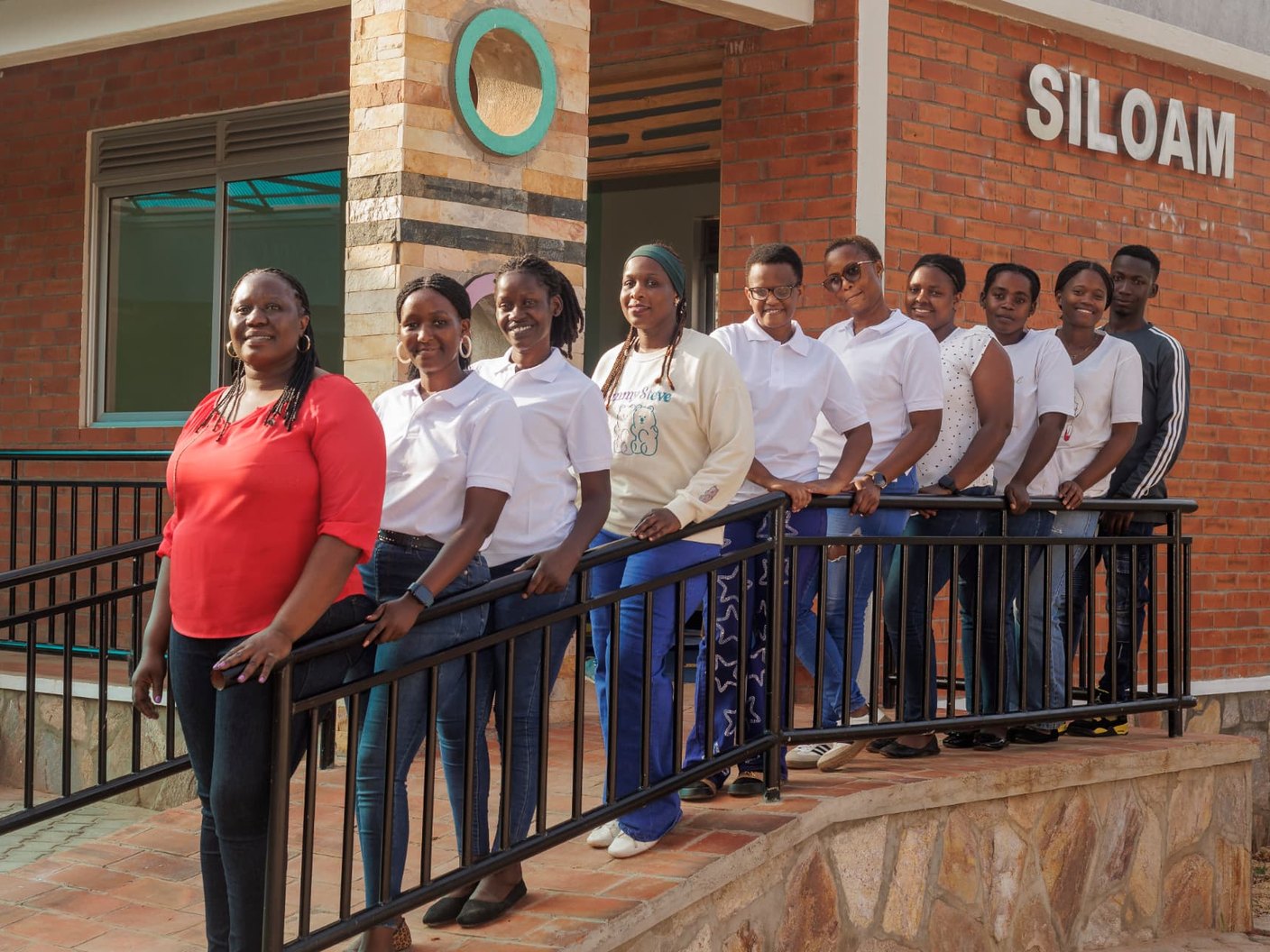 The Siloam Rehabilitation Centre team of therapists and staff standing together outside the Centre entrance in Uganda